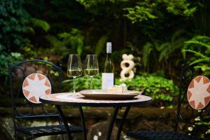 a table with two glasses of wine and a piece of cake at Mountain Sojourn - Tranquil Kurrajong Getaway in Kurrajong