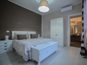 a bedroom with a white bed and a white dresser at Agrilea in Santo Stefano al Mare