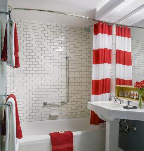 a bathroom with a red and white shower curtain and a sink at Lake House at High Peaks Resort in Lake Placid