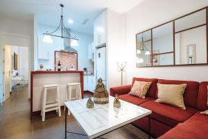 a living room with a red couch and a white table at New Amor de Dios in Seville