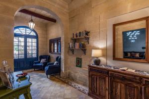 a living room with a tv and a table and chairs at The Stonehouse in St Julian's