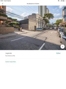 an empty street with cars parked on the side of the road at Amora Três in Sao Paulo