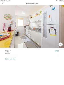 a kitchen with a white refrigerator in a room at Amora Três in São Paulo