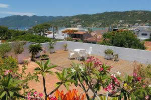 Un patio con mesa y sillas y flores. en Pousada Hotel Praia dos Anjos, en Arraial do Cabo
