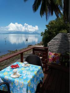 AU FARE MOENAU في Paea: طاولة مع كوبين من القهوة فوق شرفة