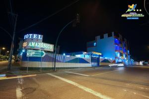 une rue vide avec un hôtel la nuit dans l'établissement Hotel Marques Amazonico, à Nueva Loja