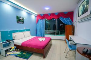 Schlafzimmer mit einem Bett, einem Schreibtisch und einem Fenster in der Unterkunft Hotel Marques Amazonico in Nueva Loja