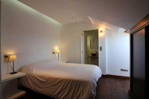 una camera da letto con un grande letto bianco e un corridoio di Casa Estrella de Garda a Buño