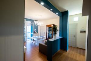 een woonkamer en eetkamer met een blauwe accentmuur bij ReLù, intero appartamento Allianz Arena (Juventus Stadium) in Turijn