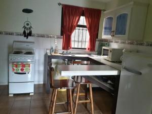 una cocina con encimera y algunas sillas. en Dos Palmas Studio Apartments, en Alajuela