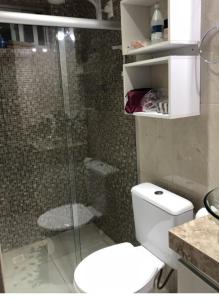 a bathroom with a glass shower and a toilet at Cobertura Vista Ampla para o Mar in Jacumã