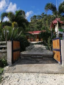 an entrance to a house with a wooden gate at MiL's Hillside Tourist Inn in San Vicente