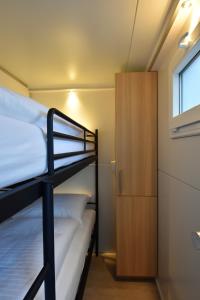 1 dormitorio con 2 literas y ventana en Cosy floating boatlodge, "Paris" en Maastricht