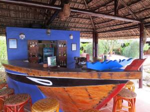 a bar with a wooden boat on the wall at Whale Island Resort in Dam Mon