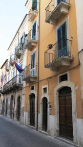 a building with two balconies and a door on a street at B&B Del Teatro in Sulmona