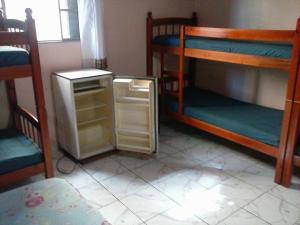 a small refrigerator in a room with bunk beds at CHACARA NOSSA SENHORA DAS DORES in Cachoeira Paulista