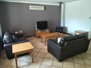 Una sala de estar con dos sofás y un televisor. en Margaret House, en Margaret River Town