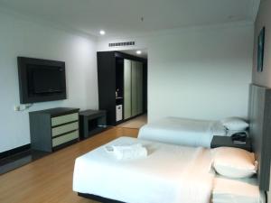 a hotel room with a bed and a tv at Purnama Hotel in Limbang