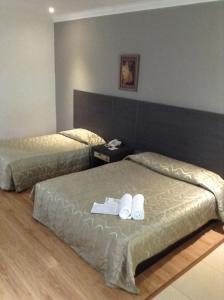 Dos camas en una habitación de hotel con toallas. en Purnama Hotel, en Limbang
