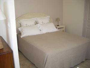 1 dormitorio con 1 cama grande con almohadas blancas en Chambres d'Hotes la Raspeliere, en Cabourg