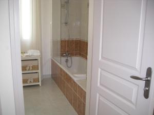 y baño con bañera, ducha y lavamanos. en Chambres d'Hotes la Raspeliere, en Cabourg