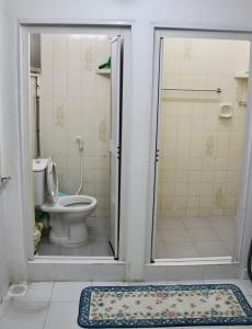 ein Bad mit WC und Dusche mit Tür in der Unterkunft Macallum Budget Muslim Homestay in George Town