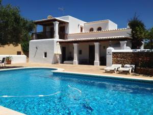 a villa with a swimming pool in front of a house at Can Gat in Sant Carles de Peralta