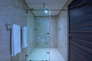 墨西哥城Econo Express Hotel的带淋浴和玻璃门的浴室