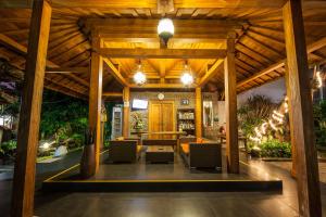 a large wooden pavilion with chairs and a table at Surya Mas Villa in Legian