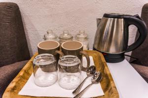 ein Tablett mit einer Kaffeekanne und zwei Gläsern auf dem Tisch in der Unterkunft Fisheye The Rooms - Room 2 in El Nido