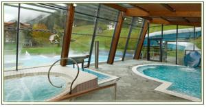 einen Pool in einem Gebäude mit einem großen Fenster in der Unterkunft Hotel Sureghes in St. Ulrich in Gröden
