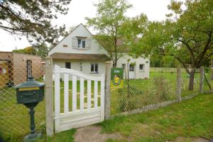 a white fence with a gate in front of a house at Gîtes de charme dans l'Essonne in Buno-Bonnevaux