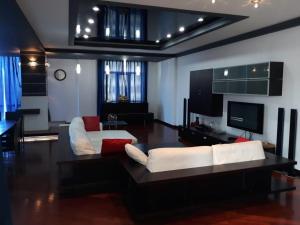 ein Wohnzimmer mit einem weißen Sofa und einem TV in der Unterkunft BAKU CITY CENTER 3. Bedrooms 3. in Baku