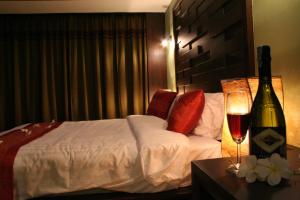 um quarto de hotel com uma cama e uma garrafa de vinho em Lamoon Lamai Residence & Guesthouse em Lamai