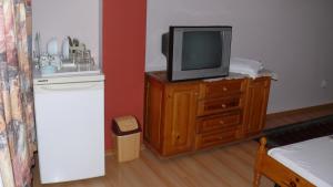 a tv sitting on top of a wooden dresser at Villa Climate Guest House in Varna City