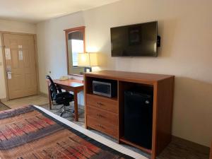 a hotel room with a desk and a flat screen tv at Best Western Grande River Inn & Suites in Grand Junction