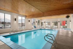 a large swimming pool with chairs in a building at Super 8 by Wyndham S Jordan/Sandy/Slc Area in South Jordan