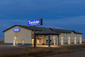 a hotel building with a sign in front of it at Travelodge by Wyndham Pincher Creek in Pincher Creek