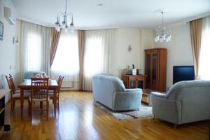 ein Wohnzimmer mit einem Sofa, einem Tisch und Stühlen in der Unterkunft Neftçilər prospekti . Bedrooms 2. in Baku