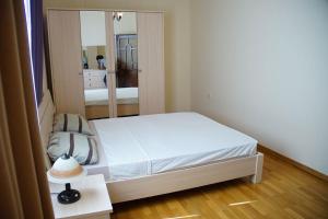 ein kleines Schlafzimmer mit einem Bett und einem Spiegel in der Unterkunft Neftçilər prospekti . Bedrooms 2. in Baku