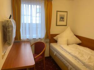 Habitación con cama, mesa y ventana en Hotel Alpenrose gut schlafen & frühstücken, en Scheidegg