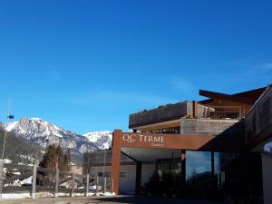 un edificio con una señal frente a una montaña en Majon de la nona en Pozza di Fassa