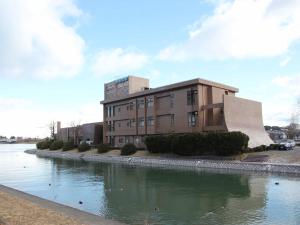 a building with a ramp in front of a body of water at Hotel ab Shiga in Otsu