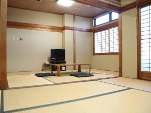 a room with a table and a tv in it at Hotel ab Shiga in Otsu