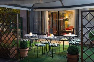 a patio with tables and chairs under an umbrella at Hotel Santa Costanza by OMNIA hotels in Rome