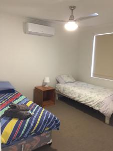 a bedroom with two beds and a night stand at SERENITY of MANDURAH in Mandurah