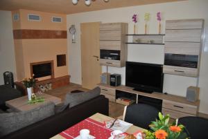 uma sala de estar com um sofá e uma televisão em Ferienwohnung Isabella em Crostau