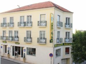 a large white building with windows and balconies at Residencial Imperial in Luso