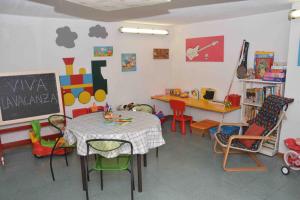 a classroom with a table and chairs and a chalkboard at Residence Mare Verde in Pietra Ligure