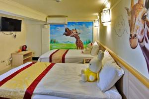 a hotel room with two beds with a giraffe mural at Shangrila in Dongyin